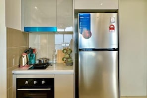 A modern kitchen with a stainless steel refrigerator, a gas stove, and a microwave. - KLCity & KLCC View Modern Style 2R2B - 6 pax (Kuala Lumpur)