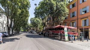 A street with a red awning, trees, and buildings. - Suite Modena al Centro - Affitti Brevi Italia (Modena)
