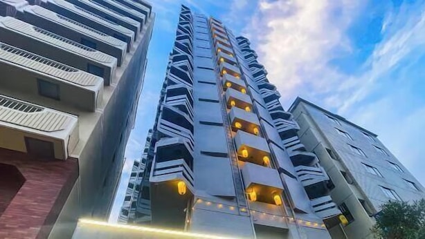 A high-rise building with multiple balconies, a modern architectural design, and a clear sky in the background. - Takinoen Standalone House for 7 12 mins Train to Ueno (Tokyo)