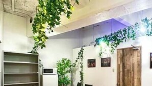 A conference room with a wooden table, black chairs, a whiteboard, and green plants. - Takinoen Standalone House for 7 12 mins Train to Ueno (Tokyo)