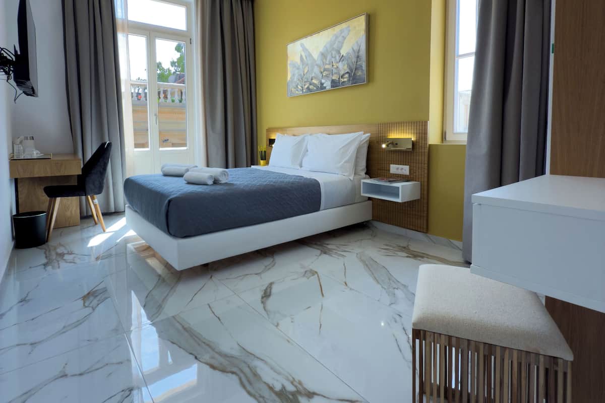 A modern bedroom with a bed, bedside table, and a desk.