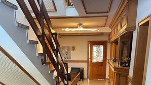 A staircase with wooden railings leading to a landing area with a tiled floor. - Gästehaus am Kurpark VS (Villingen-Schwenningen)