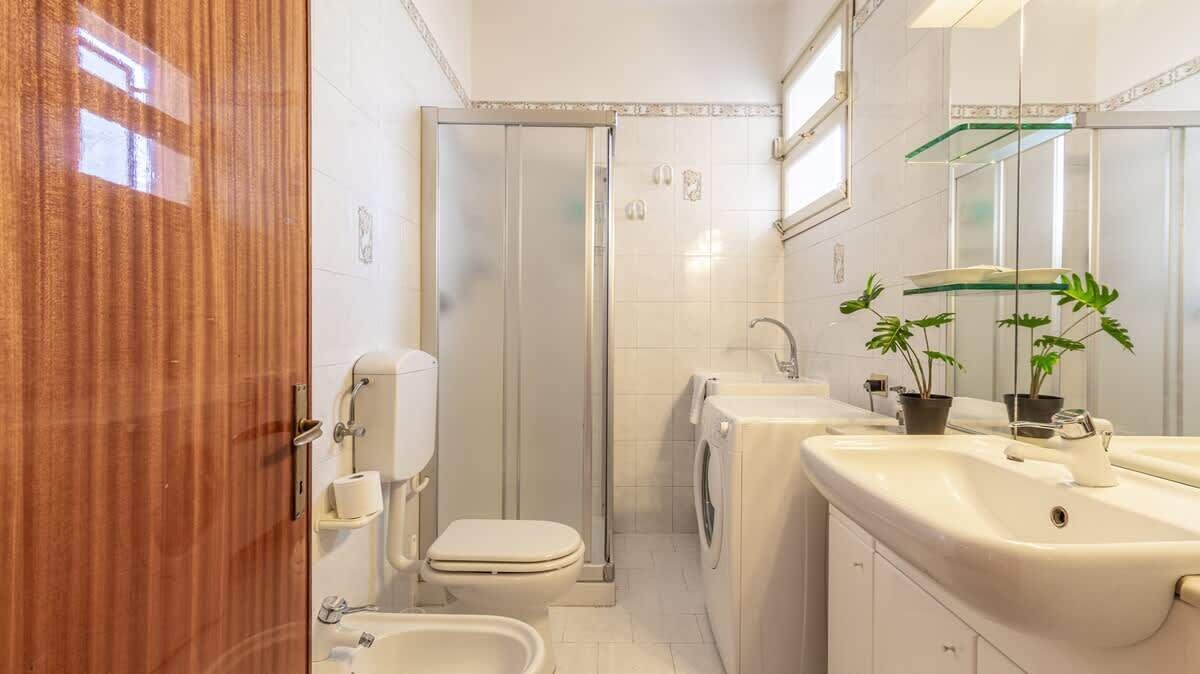 A bathroom with a toilet, bidet, and washing machine.