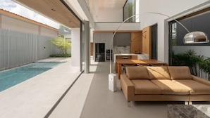 Un intérieur moderne avec une piscine, un canapé et un coin repas.