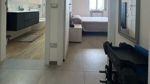 A modern hotel room with a bathroom, a bed, and a large mirror.