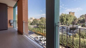 A balcony with a view of a parking lot and surrounding buildings.