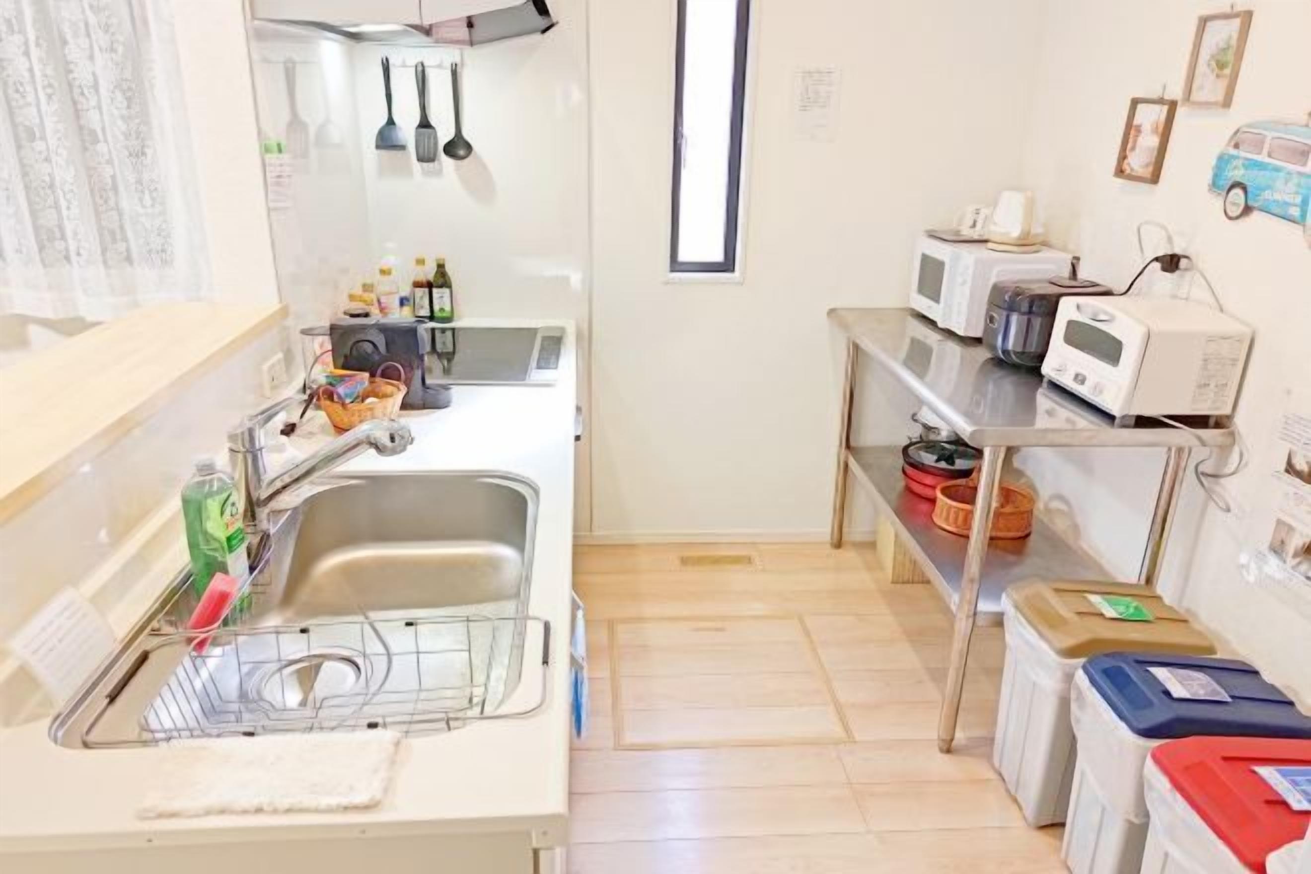 A compact kitchen with a sink, microwave, and storage shelves.