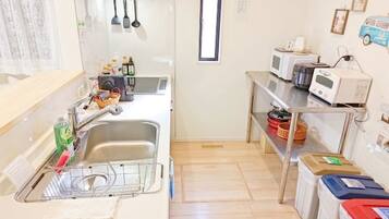 A compact kitchen with a sink, microwave, and storage shelves.