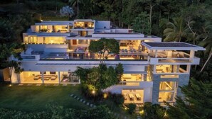 A modern multi-story house with multiple balconies and a well-lit interior. - Villa Spice Samui (Koh Samui)