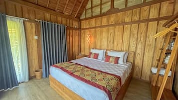 A wooden-paneled room with a bed, a nightstand, and a wardrobe.