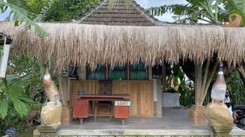 A thatched-roof structure with a wooden desk and a sign reading 'Lobbi'.