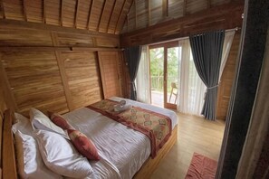A wooden room with a bed, curtains, and a view through a window. - Jatiluwih Guava Eco Living Managed by Manara (Bali)