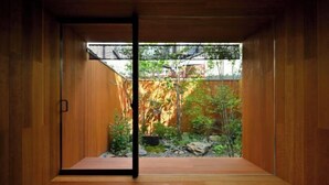 A room with wooden walls and a glass door leading to an outdoor garden with plants and rocks. - Kyo No Ondokoro Goshonishi #6 (Kyoto)
