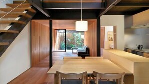 A modern interior with a wooden staircase, a dining area with a table and chairs, and a kitchen area. - Kyo No Ondokoro Goshonishi #6 (Kyoto)
