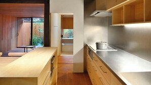 A modern kitchen with wooden cabinets, stainless steel countertops, and a view of a wooden deck. - Kyo No Ondokoro Goshonishi #6 (Kyoto)