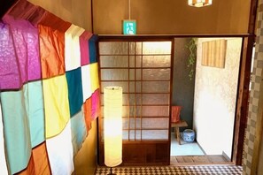 A traditional Japanese room with tatami flooring, a shoji screen door, and a hanging lantern. - Tsukamoto Collector (Osaka)