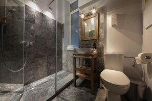 A bathroom with a glass-enclosed shower, a wooden vanity with a sink, and a toilet. - FlamingoHaven Chic&Renovated 1BRwBalcony PrimeSpot (Bucharest)