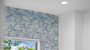 Un dormitorio con una cama grande, una ventana y una pared con diseño de olas.