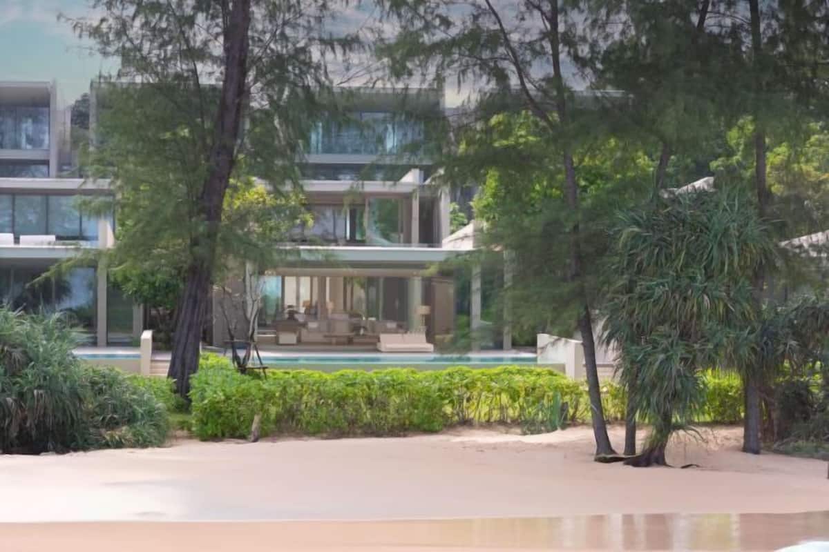 A modern building with a pool, surrounded by lush greenery and trees.