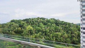 A high-rise building with a view of a dense forested hill. - Putrajaya Dwiputra 6 Plus 1 PAX Fully Air-Con (Putrajaya)