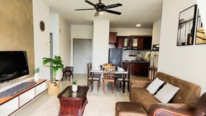 A living room with a TV, sofa, coffee table, and dining area. - Putrajaya Dwiputra 6 Plus 1 PAX Fully Air-Con (Putrajaya)