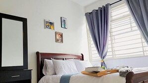 A hotel room with a bed, a bedside table, a mirror, and a window with curtains. - Putrajaya Dwiputra 6 Plus 1 PAX Fully Air-Con (Putrajaya)