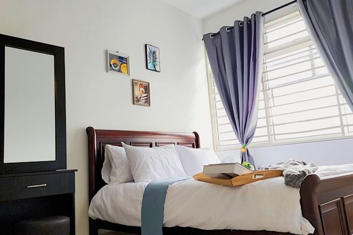 Un dormitorio con cama, mesita de noche, ventana con cortinas y decoración en la pared.
