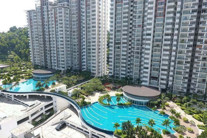 A high-rise residential building with multiple balconies and a large swimming pool area.