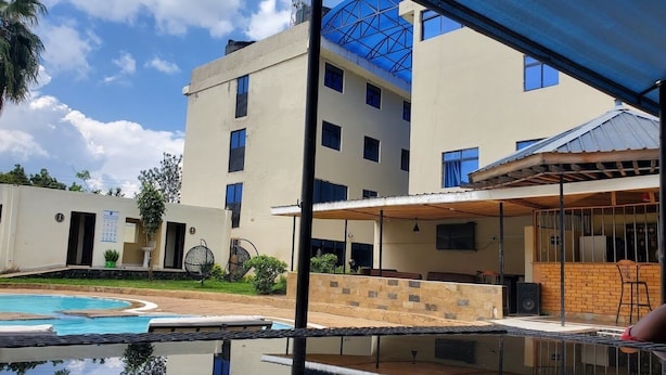 Un bâtiment moderne doté d’une piscine, d’un espace extérieur aménagé et d’un patio couvert.
