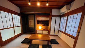 Egy hagyományos japán szoba, tatami szőnyeggel, alacsony, fából készült asztallal és tolóajtókkal.
