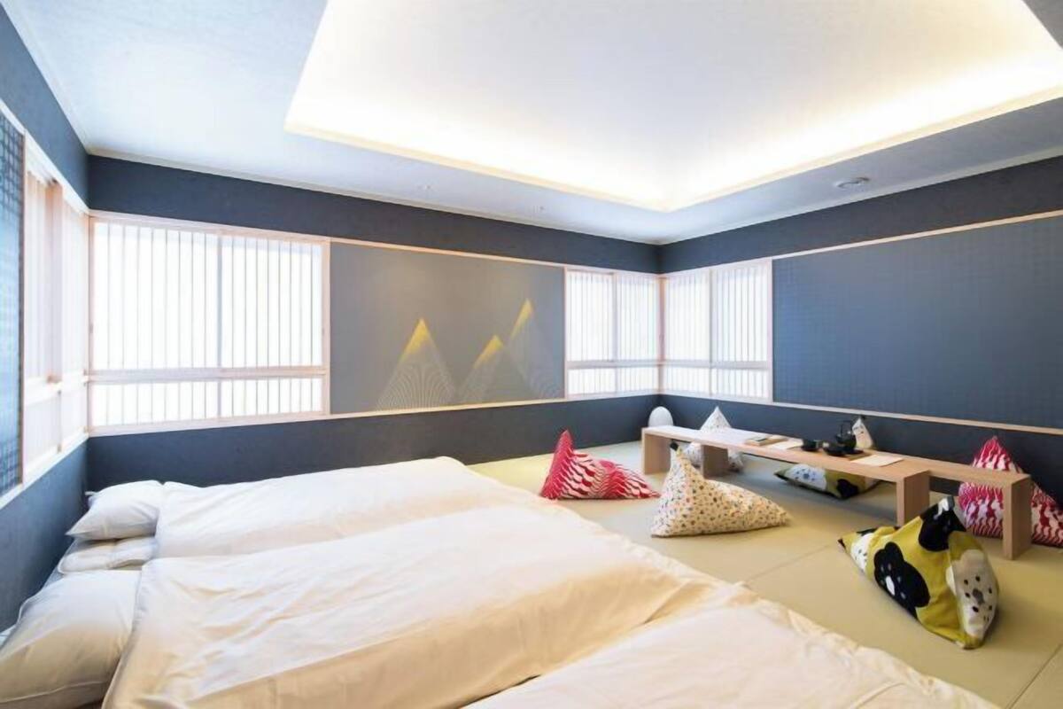 Une chambre d’hôtel moderne équipée de deux lits, d’un bureau et d’un coin salon.