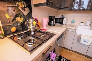 A modern kitchen with a gas stove, microwave, and dishwasher. - Gorgeous Two Bedroom Apartment - Roya (Istanbul)