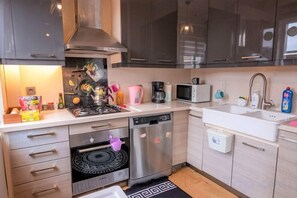 A modern kitchen with a stove, microwave, sink, and dishwasher. - Gorgeous Two Bedroom Apartment - Roya (Istanbul)