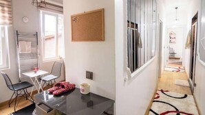 A compact living space with a dining area, a corkboard, and a hallway leading to a bedroom. - Gorgeous Two Bedroom Apartment - Roya (Istanbul)