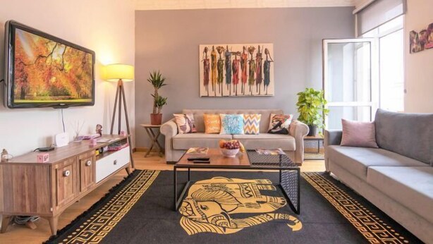 Ein Wohnzimmer mit einer Couch, einem Couchtisch und Kunstwerken an den Wänden.