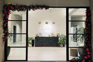 A reception area with a reception desk, two pendant lights, and a Christmas garland. - Chic studio near IT Park Smartlock Fast wifi (Cebu City)