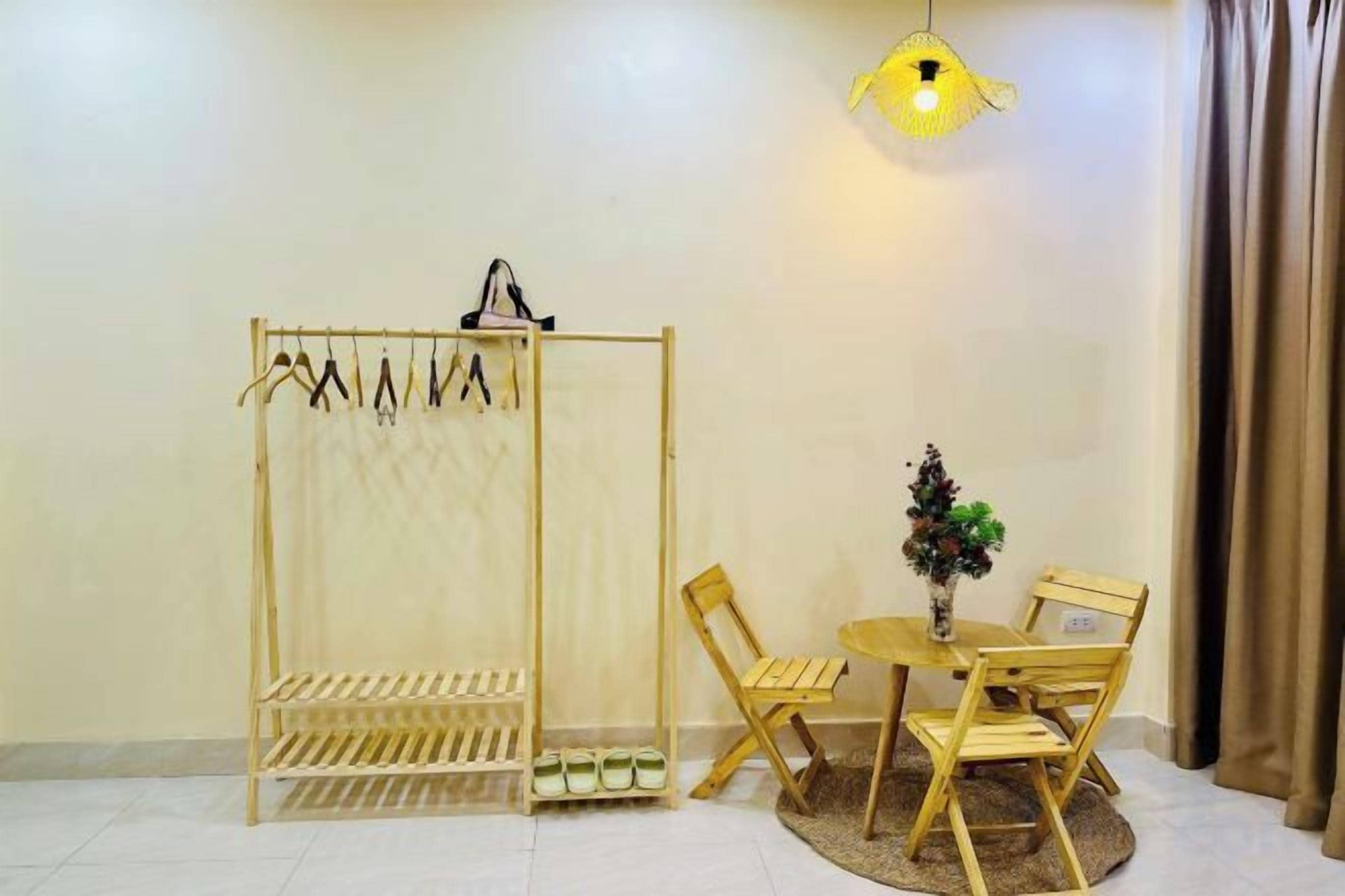 A room with a wooden chair and table, a wooden shelf unit, and a hanging light fixture.