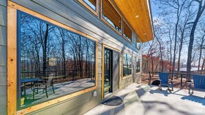 Un edificio moderno con grandes ventanales, un patio cubierto y asientos exteriores.