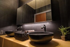 Ein modernes Badezimmer mit einem großen Spiegel, zwei Waschbecken und einer Topfpflanze.