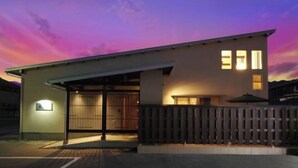 Un bâtiment moderne doté d’une entrée abritée et d’une clôture en bois.