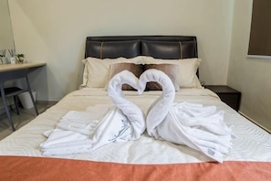 Una cama con cabecera, almohadas y una manta.