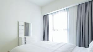A modern bedroom with a large bed, a bedside table, a mirror, and a window with curtains. - Mh- Act - Downtown 1BHK-Ref4002 (Dubai)