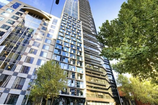 A tall, modern skyscraper with reflective glass windows and a mix of architectural styles.