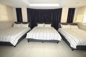 A bedroom with three beds, a skylight, and dark curtains. - Decozy 3.0 Semi-D (18pax++) (Ipoh)