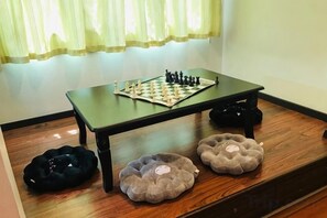 A chessboard on a table with two cushions. - Decozy 3.0 Semi-D (18pax++) (Ipoh)
