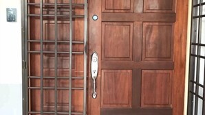 A wooden door with a metal security gate and a keyhole. - Decozy 3.0 Semi-D (18pax++) (Ipoh)
