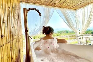 Una persona en una bañera con vistas al exterior.