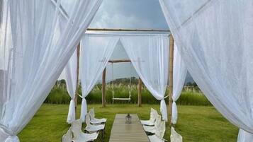 An outdoor dining area with a table and chairs under a canopy.