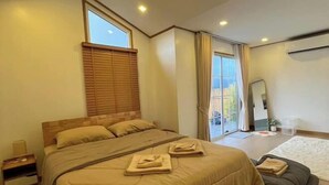 Een slaapkamer met een bed, nachtkastje, raam met zonwering, een schuifdeur en uitzicht op de omgeving.