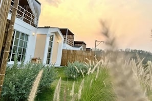 Una casa moderna con un ventanal grande, un balcón y una valla de madera.